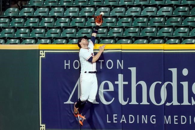 Houston Astros right fielder Josh Reddick reaches for a home run by Arizona Diamondbacks' Kole Calhoun during the eighth inning of a baseball game Friday, Sept. 18, 2020, in Houston. (AP Photo/David J. Phillip)