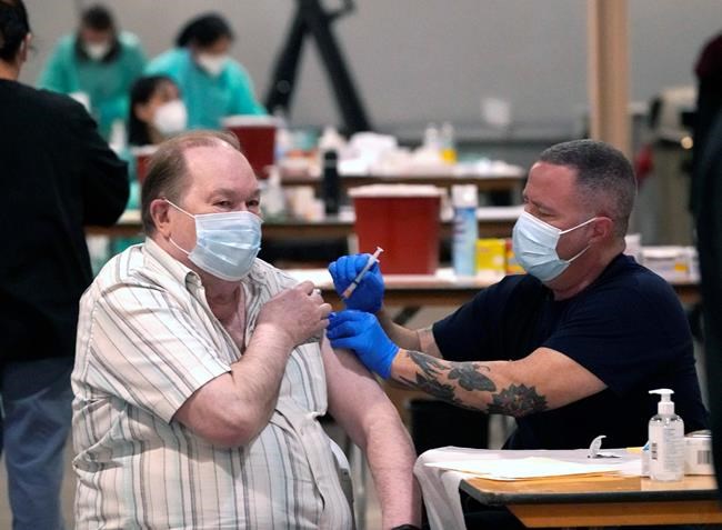 Howard Holland, 82, receives his first dose of the COVID-19 vaccine from Wes Vaughn at the Dallas County mass vaccination site at Fair Park Wednesday, Jan. 20, 2021, in Dallas. (AP Photo/LM Otero)