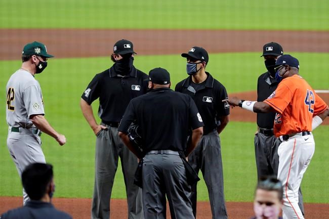Oakland Athletics manager Bob Melvin, left, and Houston Astros manager Dusty Baker Jr., right, meet at the plate with umpires before both teams stood for a moment of silence and then walked off the field to protest recent racial injustice before the start of their baseball game Friday, Aug. 28, 2020, in Houston. (AP Photo/Michael Wyke)