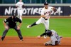 Houston Astros second baseman Jose Altuve (27) jumps to avoid the slide into second base by Colorado Rockies Trevor Story (27) as he turns a double play as umpire Bill Miller, left, looks on during the sixth inning of a baseball game Monday, Aug. 17, 2020, in Houston. (AP Photo/Michael Wyke)