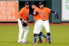 Houston Astros outfielders Michael Brantley, left, Josh Reddick, center, and George Springer, right, celebrate their win over the Oakland Athletics after the first baseball game of a doubleheader Saturday, Aug. 29, 2020, in Houston. All players and managers are wearing No. 42 as a tribute to baseball great Jackie Robinson. (AP Photo/Michael Wyke)
