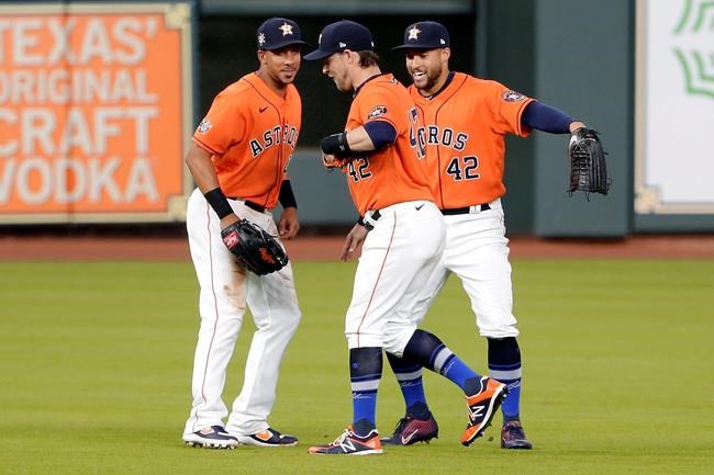 Houston Astros outfielders Michael Brantley, left, Josh Reddick, center, and George Springer, right, celebrate their win over the Oakland Athletics after the first baseball game of a doubleheader Saturday, Aug. 29, 2020, in Houston. All players and managers are wearing No. 42 as a tribute to baseball great Jackie Robinson. (AP Photo/Michael Wyke)