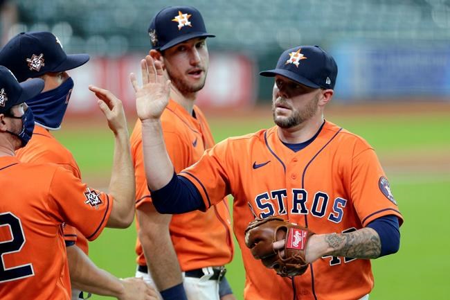 Houston Astros closing pitcher Ryan Pressly, right, collects near high-fives from teammates as Kyle Tucker, rear, watches after the team's 4-2 win over the Oakland Athletics in the first baseball game of a doubleheader Saturday, Aug. 29, 2020, in Houston. All players and managers are wearing No. 42 as a tribute to baseball great Jackie Robinson. (AP Photo/Michael Wyke)