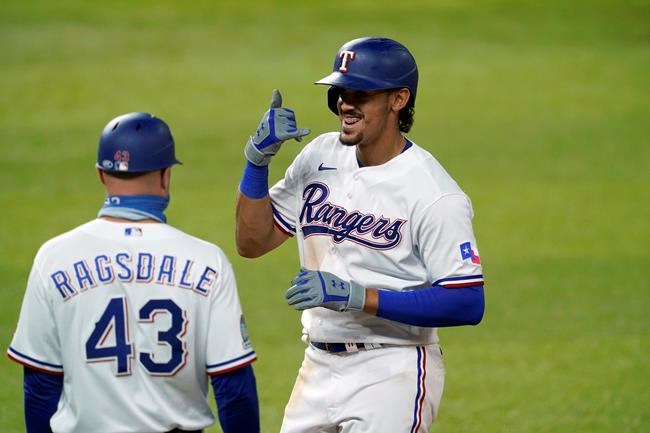 Texas Rangers first base coach Corey Ragsdale (43) watches as Ronald Guzman gestures to the dugout after hitting a single during the eighth inning of the team's baseball game against the Los Angeles Angels in Arlington, Texas, Tuesday, Sept. 8, 2020. (AP Photo/Tony Gutierrez)