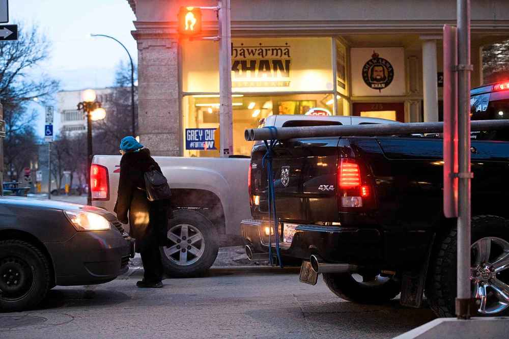Mike Sudoma / Winnipeg Free Press
A pedestrian makes their way across Mcdermott Ave in rush hour traffic Thursday evening in front of Shawarma Khan restaurant. The restaurant