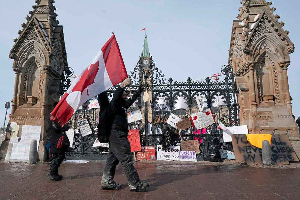 A protestor walks past the Queen’s gate as a trucker protest continues in downtown Ottawa on Tuesday, Feb. 1, 2022. THE CANADIAN PRESS/Adrian Wyld