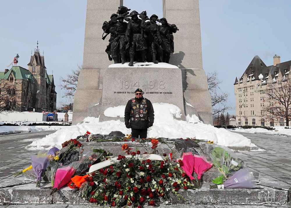 Boisvenu Carloman, a Canadian Armed Forces veteran from Plantagenet, Ont., stands guard at the Tomb of the Unknown Soldier at the National War Memorial after he saw images of the tomb being disrespected as a rally against COVID-19 restrictions, which began as a cross-country convoy protesting a federal vaccine mandate for truckers, continues in Ottawa, on Tuesday, February 1, 2022. THE CANADIAN PRESS/Patrick Doyle