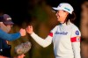 Hinako Shibuno, of Japan, fist bumbs fellow players after her round of golf during the third round of the U.S. Women's Open golf tournament, Saturday, Dec. 12, 2020, in Houston. (AP Photo/Eric Gay)