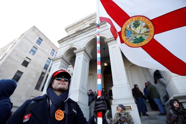 Kevin Thompson, of Vero Beach Fla., demonstrates during a pro-gun rally, Monday, Jan. 20, 2020, in Richmond, Va. Thousands of pro-gun supporters are expected at the rally to oppose gun control legislation like universal background checks that are being pushed by the newly elected Democratic legislature. (AP Photo/Julio Cortez)