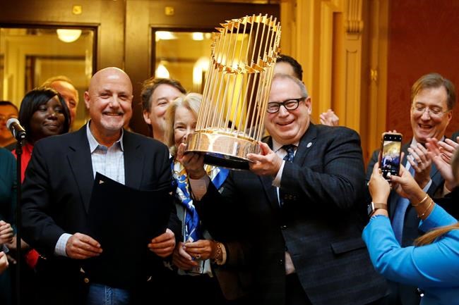 Del. Mark Sickles, D-Fairfax., right, holds the Washington Nationals World Series trophy as Nationals president and General Manager, Mike Rizzo, left, looks on as the Virginia House of Delegates honors the team during the session at the Capitol Tuesday Jan 28, 2020, in Richmond, Va. (AP Photo/Steve Helber)