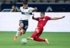 Vancouver Whitecaps' Ryan Raposo, left, is taken down by Toronto FC's Auro Jr. during the second half of an MLS soccer game in Vancouver, on Saturday, September 5, 2020. THE CANADIAN PRESS/Darryl Dyck