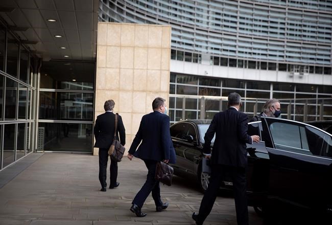 Britain's chief negotiator David Frost, center, leaves EU headquarters after a meeting with EU chief negotiator Michel Barnier in Brussels, Sunday, Dec. 20, 2020. The EU and the United Kingdom were still working Sunday on a