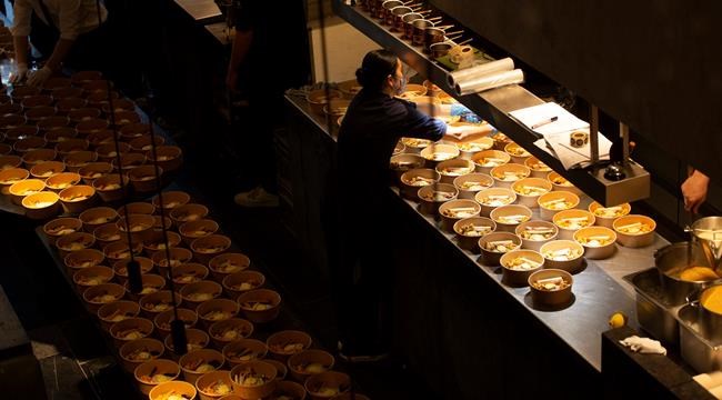 A staff member works on a dish as she helps to prepare part of nearly 600 take-away orders at Sergio Herman's Le Pristine restaurant in Antwerp, Belgium, Saturday, Nov. 7, 2020. Of all the many challenges the pandemic throws up for all kinds of professions, this one has been particularly tough: How to put a three-star chef into a takeout box. (AP Photo/Virginia Mayo)