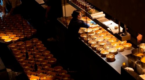 A staff member works on a dish as she helps to prepare part of nearly 600 take-away orders at Sergio Herman's Le Pristine restaurant in Antwerp, Belgium, Saturday, Nov. 7, 2020. Of all the many challenges the pandemic throws up for all kinds of professions, this one has been particularly tough: How to put a three-star chef into a takeout box. (AP Photo/Virginia Mayo)