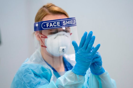A staff member receives training on how to put on and remove PPE at the Nightingale Hospital North West set up in the Manchester Central Convention Complex in Manchester, England. (AP Photo/Jon Super)