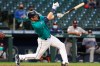 Seattle Mariners' Mitch Haniger singles on a line drive during the third inning of the team's baseball game against the Houston Astros on Friday, April 16, 2021, in Seattle. (AP Photo/Jason Redmond)