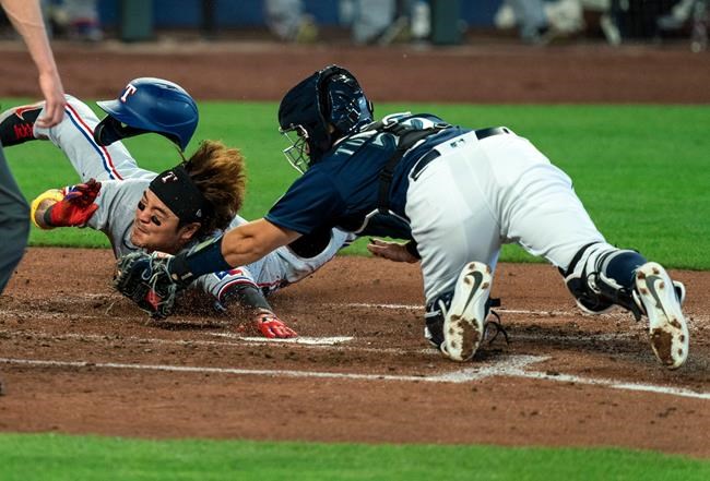 Texas Rangers' Shin-Soo Choo, left, touches home plate to score before Seattle Mariners catcher Luis Torrens, right, can make a tag on a two-run double by Rangers' Joey Gallo off Mariners starting pitcher Marco Gonzales during the fourth inning of a baseball game, Monday, Sept. 7, 2020, in Seattle. (AP Photo/Stephen Brashear)