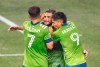 Seattle Sounders gather around captain Nicolas Lodeiro, center, after he scored the second of two penalty kicks in the first half of an MLS soccer match against Los Angeles FC, Friday, Sept. 18, 2020, in Seattle. (Dean Rutz/The Seattle Times via AP)