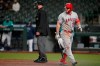 Los Angeles Angels' Mike Trout, right, reacts after being called out on strikes during the sixth inning of the team's baseball game against the Seattle Mariners, Friday, April 30, 2021, in Seattle. (AP Photo/Ted S. Warren)