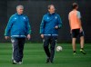 FILE - In this Oct. 27, 2015, file photo, Seattle Sounders head coach Sigi Schmid, left, watches player drills with assistant coach Brian Schmetzer, center, during an MLS soccer training session in Tukwila, Wash. Nearly two years after he died, Schmid’s presence and influence is being heavily felt heading into Saturday’s MLS Cup final between Columbus and Seattle. (AP Photo/Ted S. Warren, File)