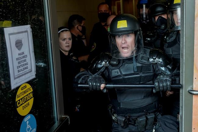 Police try to secure the public safety building from protesters Monday, Aug. 24, 2020, in Kenosha, Wis.Wisconsin Gov. Tony Evers has summoned the National Guard to head off another round of violent protests after the police shooting of a Black man under murky circumstances turned Kenosha into the nation’s latest flashpoint city in a summer of racial unrest. (AP Photo/Morry Gash)
