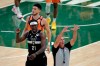 Milwaukee Bucks guard Jrue Holiday (21) reacts in front of Phoenix Suns guard Devin Booker during the first half of Game 6 of basketball's NBA Finals Tuesday, July 20, 2021, in Milwaukee. (AP Photo/Aaron Gash)