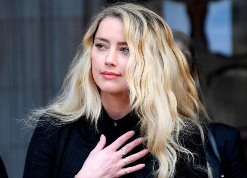 FILE - In this file photo dated Tuesday, July 28, 2020, American actress Amber Heard, former wife of actor Johnny Depp, gestures as she gives a statement after the end of the trial outside the High Court in London. A British judge is set to deliver his judgement in writing on Monday Nov. 2, 2020, deciding whether a tabloid newspaper defamed Depp by calling him a “wife beater.