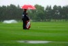 A general view as a caddy shelters from the falling rain and standing waters gather on the sixth fairway during day one of the UK Championship golf tournament at The Belfry, in Sutton Coldfield, England, Thursday Aug. 27, 2020. Poor conditions seem to be getting worse Thursday as inclement weather closes in. (David Davies/PA via AP)