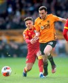 Wolverhampton Wanderers' Diogo Jota, centre, and Norwich City's Max Aarons in action during their English Premier League soccer match at Molineux stadium in Wolverhampton, England, Sunday Feb. 23, 2020. (Nick Potts/PA via AP)