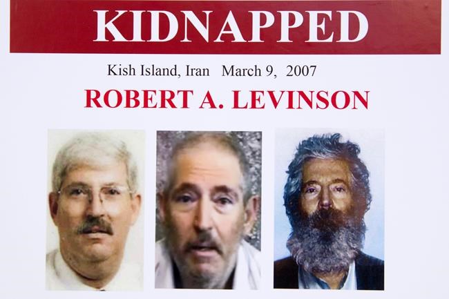 FILE - In this March 6, 2012, file photo, an FBI poster showing a composite image of former FBI agent Robert Levinson. At right, is a photo of how he would look like after five years in captivity, and an image, center, taken from the video, released by his kidnappers, and a picture before he was kidnapped, left, displayed during a news conference in Washington. The U.S. government is for the first time formally blaming Iran for the presumed death of retired FBI agent Robert Levinson. Officials on Monday publicly identified two Iranian intelligence officers believed responsible for his abduction. (AP Photo/Manuel Balce Ceneta, File)