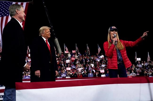 FILE - In this Dec. 5, 2020, file photo Sen. Kelly Loeffler, R-Ga., speaks as President Donald Trump and Sen. David Perdue, R-Ga., listen at a campaign rally at Valdosta Regional Airport, Saturday, Dec. 5, 2020, in Valdosta, Ga. Many Republican voters in Georgia are angry; certain that widespread voter fraud — claims of which are baseless — cost President Donald Trump the election. Most Republican voters in the state interviewed said they were prepared to put their skepticism aside to vote for Perdue and Loeffler in their races against Democrats Jon Ossoff and Raphael Warnock. (AP Photo/Evan Vucci, File)