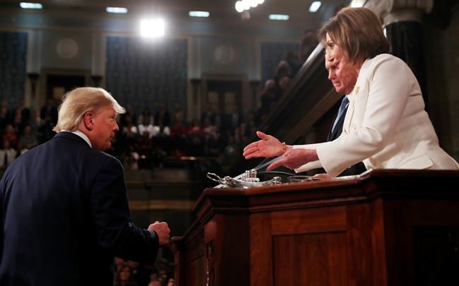 President Donald Trump arrives to deliver his State of the Union address to a joint session of Congress in the House Chamber on Capitol Hill in Washington, Tuesday, Feb. 4, 2020, as Speaker Nancy Pelosi reaches to shake his hand. (Leah Millis/Pool via AP)