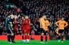 Referee Anthony Taylor, 2nd left, gestures while players wait for the VAR decision on Liverpool's opening goal during the English Premier League soccer match between Liverpool and Wolverhampton Wanderers at Anfield Stadium, Liverpool, England, Sunday Dec. 29, 2019. (AP Photo/Jon Super)