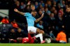 Manchester United's Aaron Wan-Bissaka, on the ground, tackles Manchester City's Raheem Sterling during the English League Cup semifinal second leg soccer match between Manchester City and Manchester United at Etihad stadium in Manchester, England, Wednesday, Jan. 29, 2020. (AP Photo/Dave Thompson)