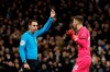 Referee David Coote shows a yellow card to Southampton's goalkeeper Angus Gunn during the English FA Cup fourth round replay soccer match between Tottenham Hotspur and Southampton at the Tottenham Hotspur Stadium in London, Wednesday, Feb. 5, 2020. (AP Photo/Kirsty Wigglesworth)