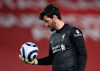 Liverpool's goalkeeper Alisson looks down at the ball during the English Premier League soccer match between Liverpool and Everton at Anfield in Liverpool, England, Saturday, Feb. 20, 2021. Everton won the game 2-0. (Lawrence Griffiths/ Pool via AP)