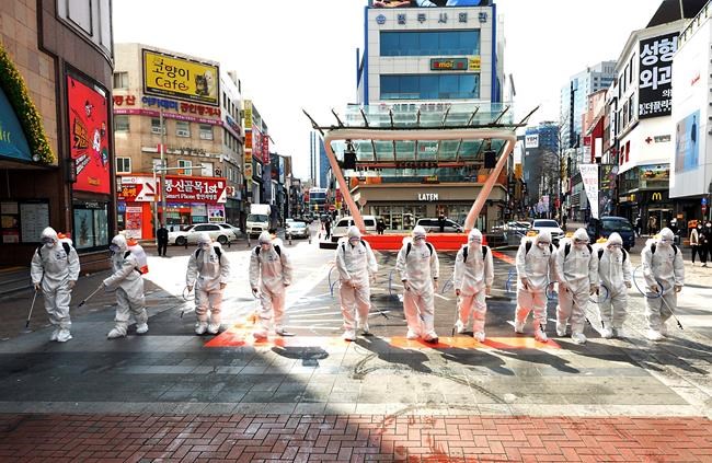 South Korean army soldiers wearing protective suits spray disinfectant to prevent the spread of the COVID-19 on a street in Daegu, South Korea, Thursday, Feb. 27, 2020. As the worst-hit areas of Asia continued to struggle with a viral epidemic, with hundreds more cases reported Thursday in South Korea and China, worries about infection and containment spread across the globe. (Lee Moo-ryul/Newsis via AP)