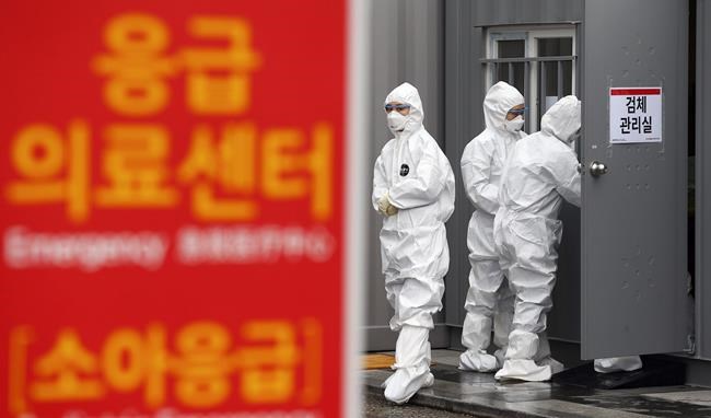 Officials wearing protective attire work to diagnose people with suspected symptoms of the new coronavirus at a hospital in Daegu, South Korea, Wednesday, Feb. 26, 2020. The number of new virus infections in South Korea jumped again Wednesday and the U.S. military reported its first case among its soldiers based in the Asian country, with his case and many others connected to a southeastern city with an illness cluster. A sign reads
