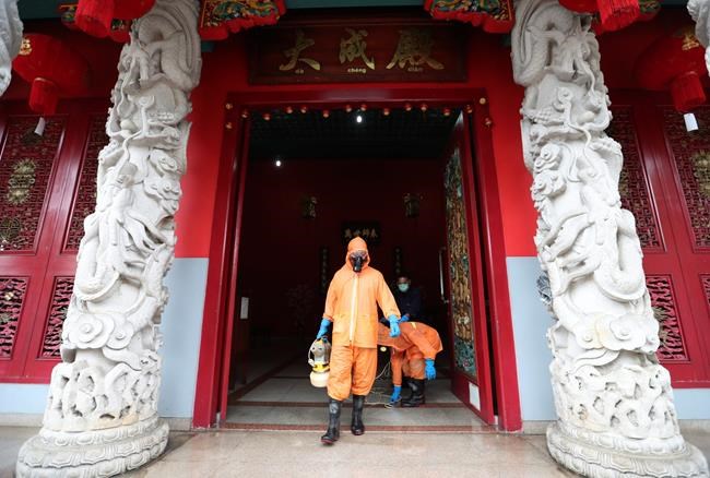 Workers sprays disinfectant at the Kong Miao Temple in Jakarta, Indonesia, Wednesday, March 18, 2020. Indonesia's capital city announced a lockdown of all tourist destinations and entertainment as well as the closing of all of its public schools amid the global outbreak. For most people, the new coronavirus causes only mild or moderate symptoms. For some, it can cause more severe illness, especially in older adults and people with existing health problems. (AP Photo/Achmad Ibrahim)