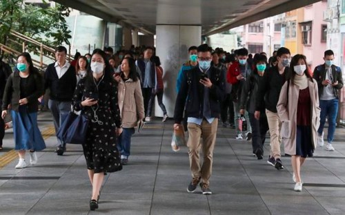 People wear protective face masks on a bridge in Hong Kong, Friday, Jan 24, 2020. China closed off a city of more than 11 million people Thursday, halting transportation and warning against public gatherings, to try to stop the spread of a deadly new virus that has sickened hundreds and spread to other cities and countries in the Lunar New Year travel rush. (AP Photo/Achmad Ibrahim)