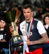 FILE - In this May 19, 2019 file photo, Juventus' Mario Mandzukic holds the Serie A soccer title trophy, at the Allianz Stadium in Turin, Italy. AC Milan has signed veteran forward Mario Mandžukic. The 34-year-old Croat gives 39-year-old Zlatan Ibrahimovic support in attack for the Italian league leader’s title challenge. Milan said Mandžukic agreed on a deal until the end of the current season with an option to extend by one year. (AP Photo/Antonio Calanni)