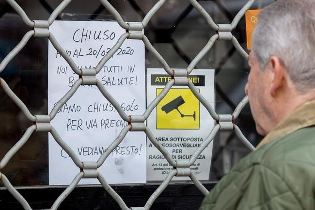 A sign on a closed shop reads, in Italian: