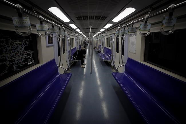 Few commuters ride in an almost empty subway train in Beijing, Monday, Feb. 24, 2020. Regulators on promised tax cuts and other aid Monday to help companies recover from China's virus outbreak and expressed confidence the ruling Communist Party's growth targets can be achieved despite anti-disease controls that shut down much of the economy. (AP Photo/Andy Wong)
