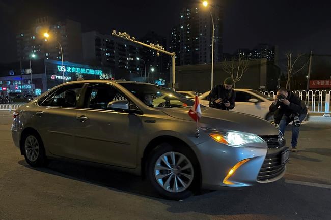 Photographers take pictures of a vehicle carrying Jim Nickel, the deputy chief of mission for the Canadian Embassy in China moves past the No. 2 Intermediate People's Court in Beijing, Monday, March 22, 2021. A second Canadian citizen held for more than two years on spying charges in apparent retaliation for Canada's arrest of a senior executive of Chinese telecoms giant Huawei went on trial in Beijing on Monday. (AP Photo)
