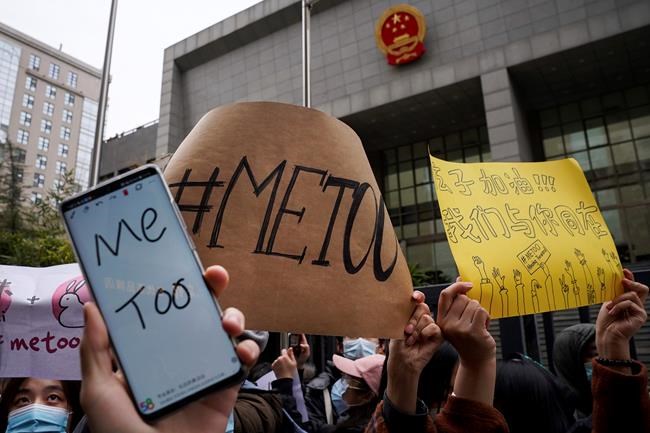 Supporters hold banners as they wait for of Zhou Xiaoxuan outside at a courthouse where Zhou is appearing in a sexual harassment case in Beijing on Wednesday, Dec. 2, 2020. In a blow to the MeToo movement in China, a court in Zhejiang province found a young man and woman guilty of defamation against a prominent Chinese journalist on Tuesday, Jan. 5, 2021 for publishing an alleged account of sexual harassment. (AP Photo/Andy Wong)