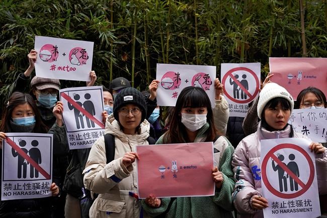 Supporters hold banners as they wait for of Zhou Xiaoxuan outside at a courthouse where Zhou is appearing in a sexual harassment case in Beijing on Wednesday, Dec. 2, 2020. In a blow to the MeToo movement in China, a court in Zhejiang province found a young man and woman guilty of defamation against a prominent Chinese journalist on Tuesday, Jan. 5, 2021 for publishing an alleged account of sexual harassment. (AP Photo/Andy Wong)