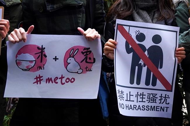 Supporters hold banners as they wait for of Zhou Xiaoxuan outside at a courthouse where Zhou is appearing in a sexual harassment case in Beijing on Wednesday, Dec. 2, 2020. In a blow to the MeToo movement in China, a court in Zhejiang province found a young man and woman guilty of defamation against a prominent Chinese journalist on Tuesday, Jan. 5, 2021 for publishing an alleged account of sexual harassment. (AP Photo/Andy Wong)