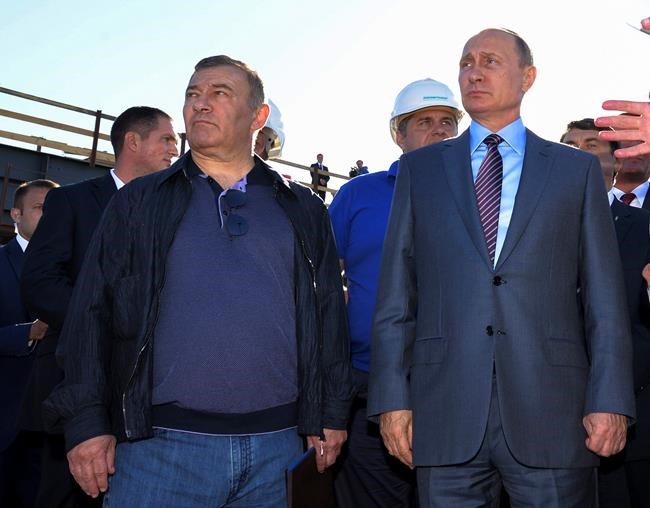 FILE - In this Sept. 15, 2016, file photo, Russian President Vladimir Putin, right, joins businessman and billionaire Arkady Rotenberg, during to a visit to the construction site of the Kerch Strait bridge in Kerch, Crimea. Putin has said that neither he nor any of his close relatives own the lavish Black Sea residence property featured in a video Alexei Navalny's team released. shortly after his arrest. On Saturday, Jan. 30, 2021, construction magnate Arkady Rotenberg, a close Putin associate and his sometimes judo sparring partner, claimed he owned the property. (Alexei Druzhinin/Sputnik, Kremlin, File Pool Photo via AP, File)