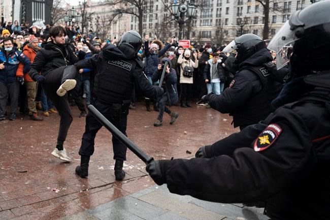A demonstrator clashes with a police officer during a protest against the jailing of opposition leader Alexei Navalny in Pushkin square in Moscow, Russia, Saturday, Jan. 23, 2021. Russian police arrested more than 3,400 people Saturday in nationwide protests demanding the release of opposition leader Alexei Navalny, the Kremlin's most prominent foe, according to a group that counts political detentions. In Moscow, an estimated 15,000 demonstrators gathered in and around Pushkin Square in the city center, where clashes with police broke out and demonstrators were roughly dragged off by helmeted riot officers to police buses and detention trucks. Some were beaten with batons. (AP Photo/Victor Berezkin)