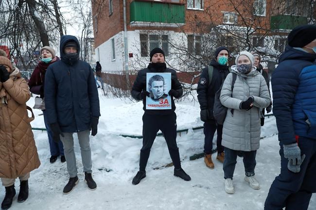 Supporters of Russian opposition leader Alexei Navalny, one of them holding his portrait on a poster reading